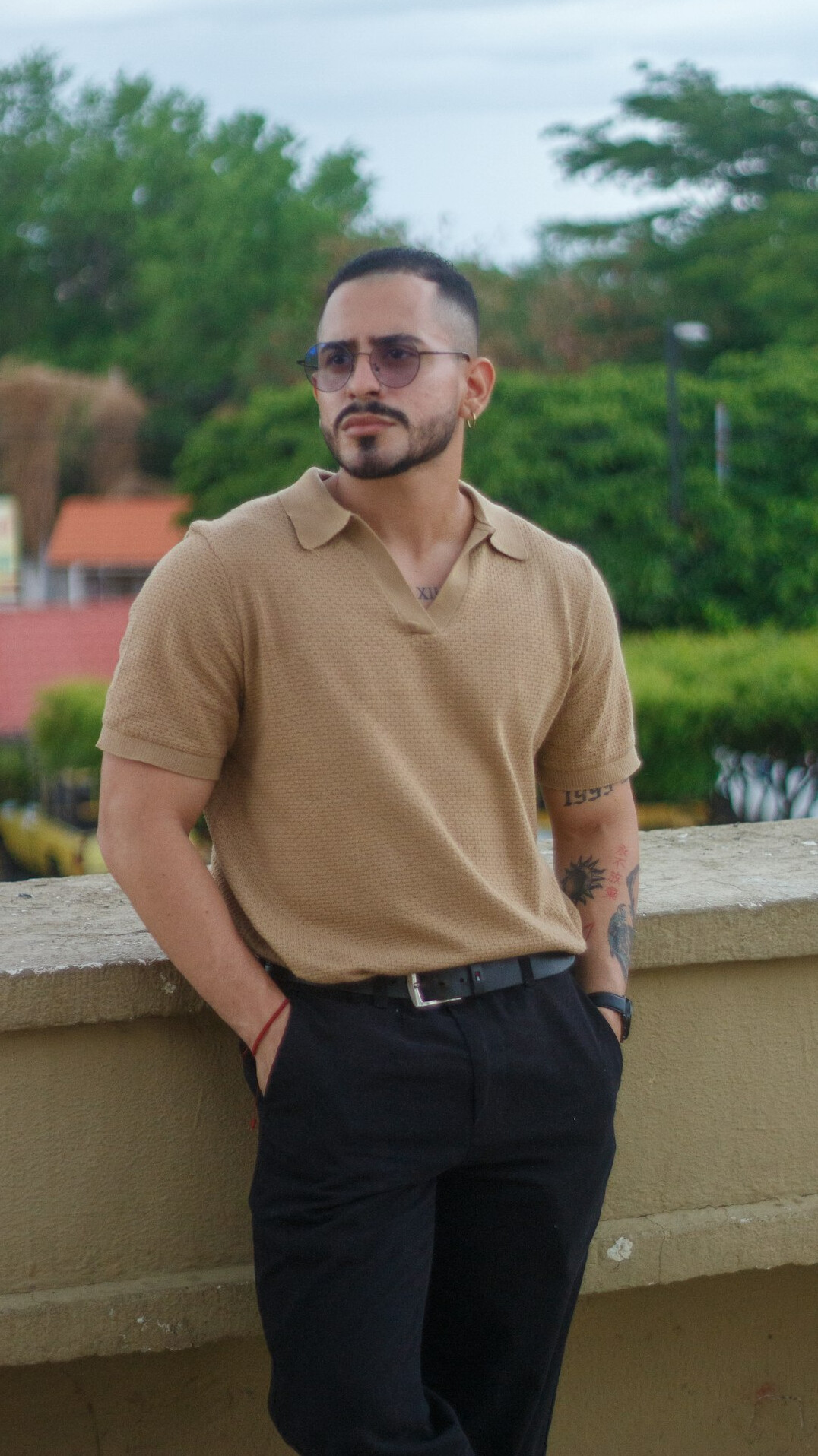 Latin man with a trimmed beard and glasses in business casual clothes