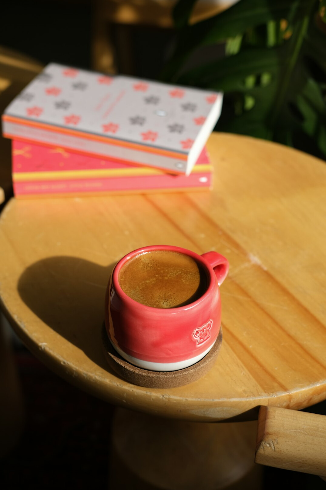 Stack of glossy magazines on a wooden table with a cup of coffee